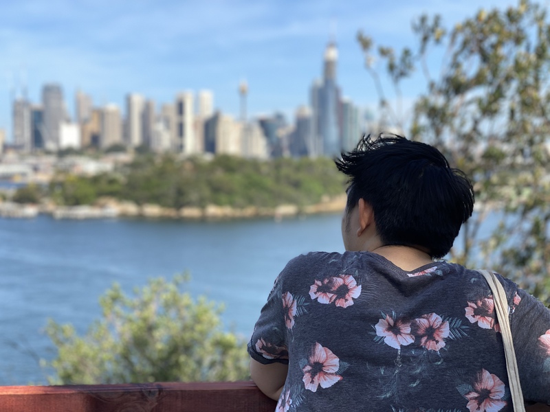 A view of a man looking out towards the CBD across the ocean