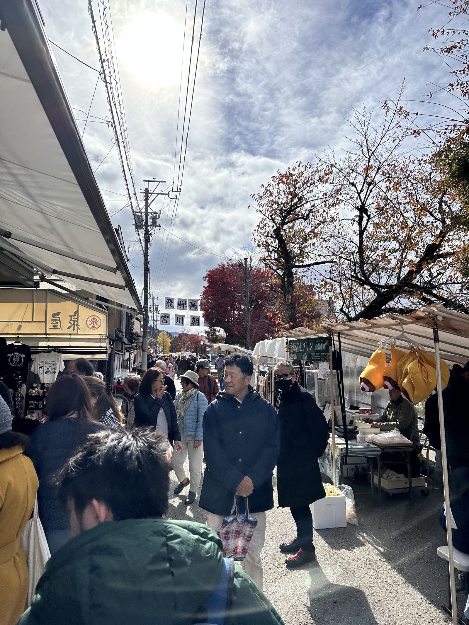 A photo of a market, with stalls on either side and lots of people